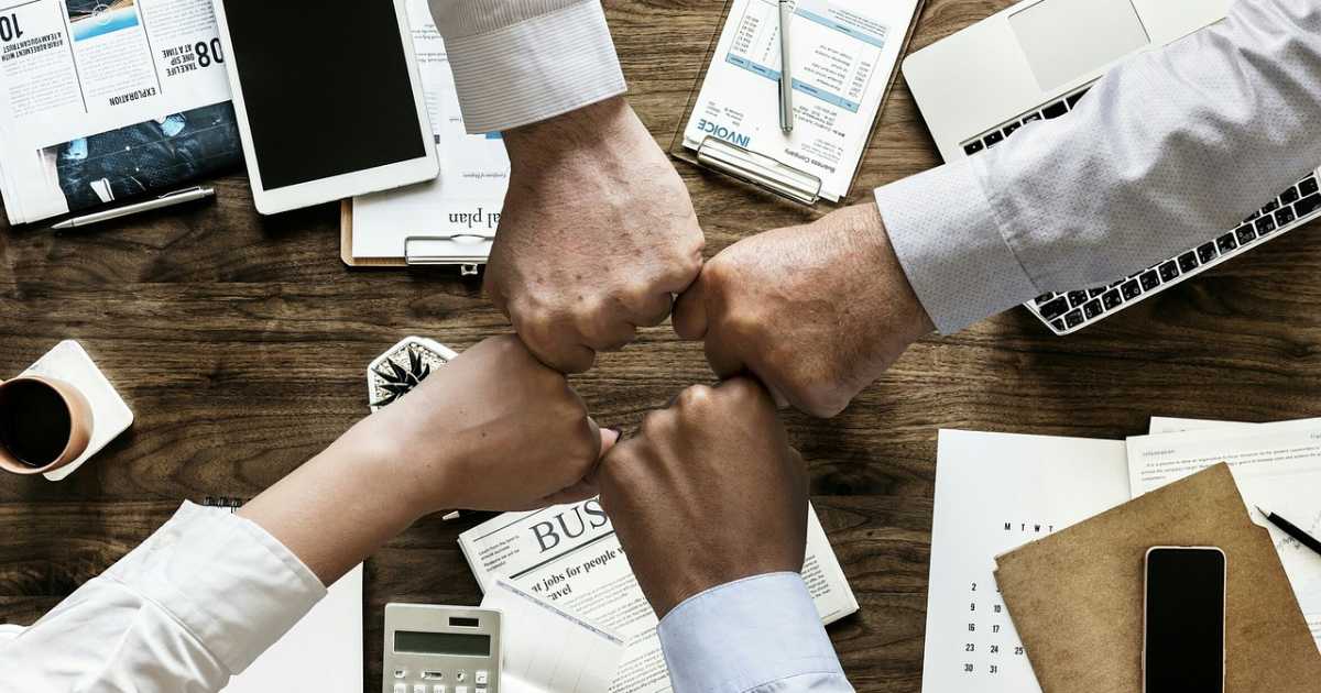 How do HR consultants drive employee health and well being initiatives? | Group of multiethnic young business friends gathered in a modern office conference room and worked as a team.